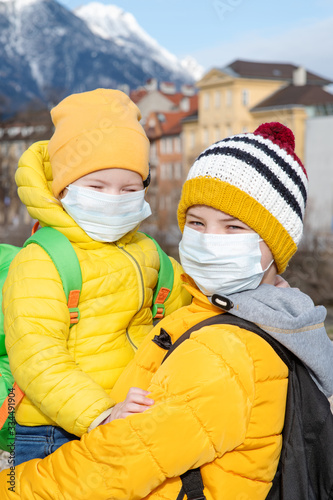 Children walking on the street in medical masks. The concept of autumn diseases. Coronavirus pandemic