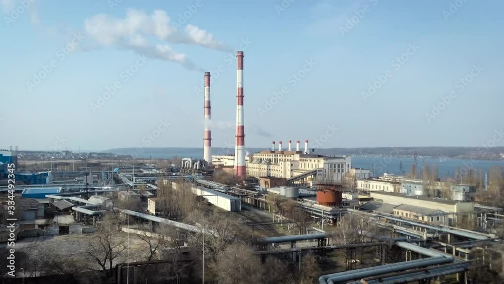 Aerial view of high chimney pipes with grey smoke from coal power plant. Production of electricity with fossil fuel. Aerial view of high chimney pipes with grey smoke from coal power plant. Production of electricity with fossil fuel.