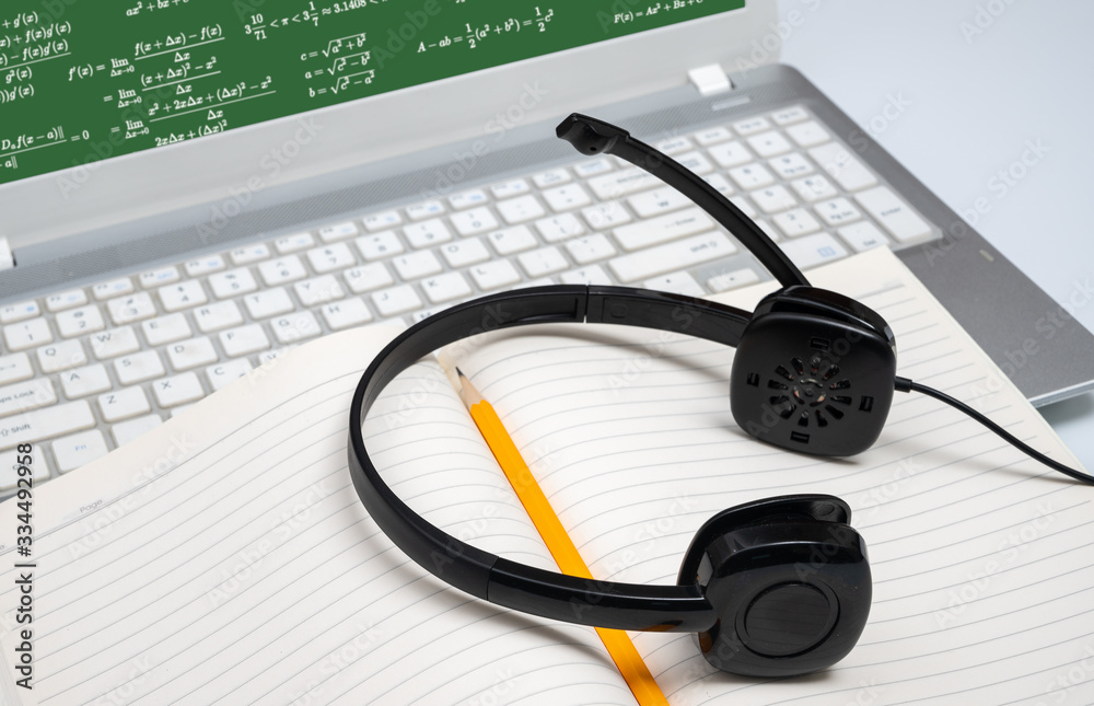 Online learning concept. There are a lined notebook and a yellow pencil on the keyboard of the laptop. Online learning concept. There are a lined notebook and a yellow pencil on the keyboard of the laptop.