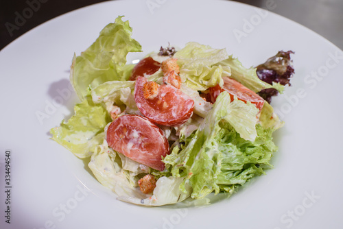 Delicious fresh caesar salad on a large white plate.