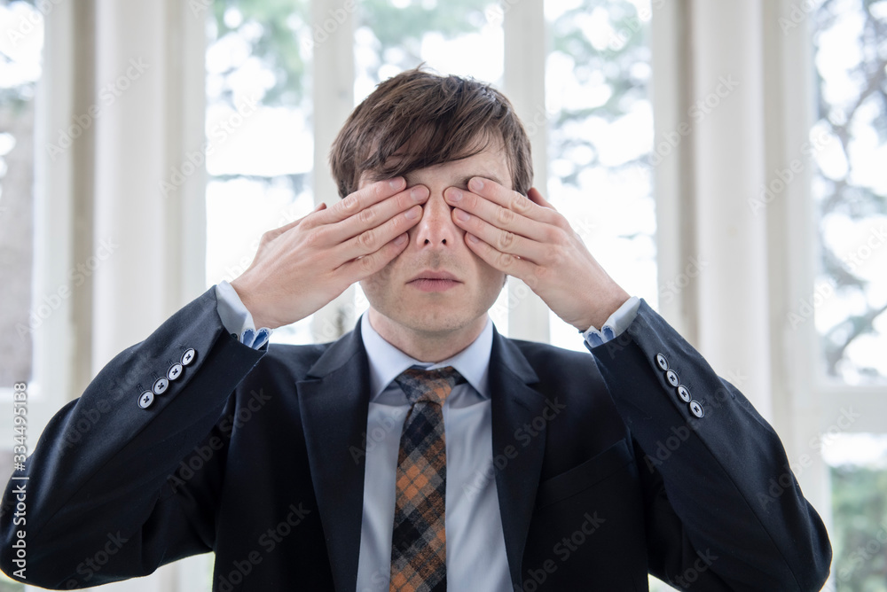 Man in a suit covering his eyes with the hands -Three wise monkeys Man in a suit covering his eyes with the hands -Three wise monkeys