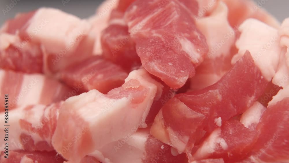 Raw fresh meat chunks or chopped pork ham in bowl or chalkboard Raw fresh meat chunks or chopped pork ham in bowl or chalkboard