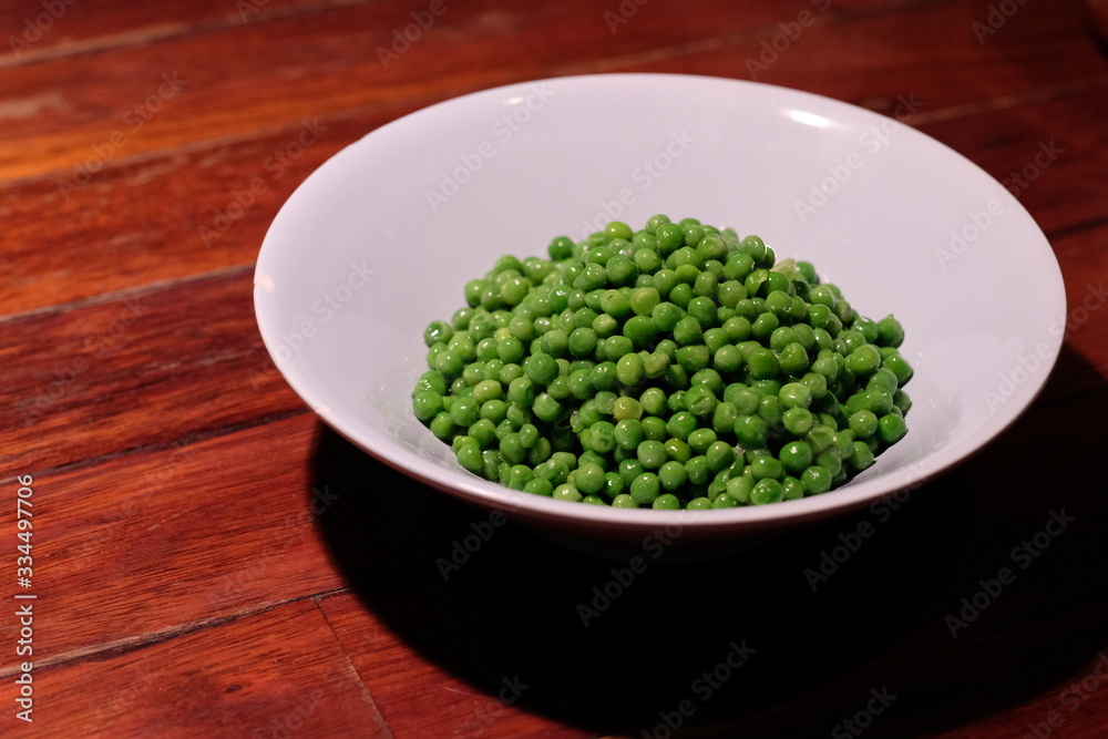 close up a bowl of cooked green soya bean on wooden table. blur background close up a bowl of cooked green soya bean on wooden table. blur background