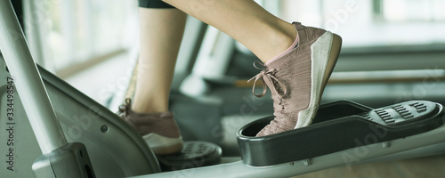 Young athlete Asia woman exercise intense cardio workout in the indoor gym. Woman using elliptical machine for cardio exercise. Healthy and wellness concept.