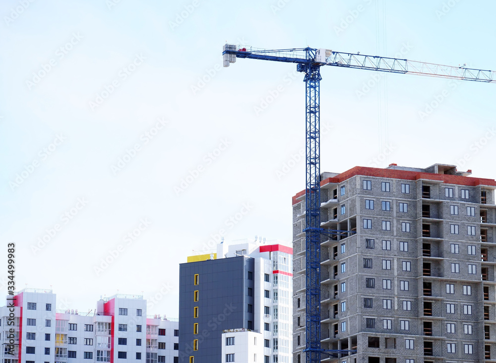 A tower crane works on a construction site. Builders carry out lifting work. The construction of a high-rise building A tower crane works on a construction site. Builders carry out lifting work. The construction of a high-rise building