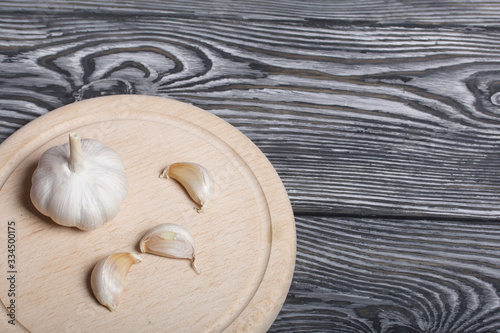 Head of garlic, a few cloves of garlic. They lie on the surface of brushed pine boards. photo