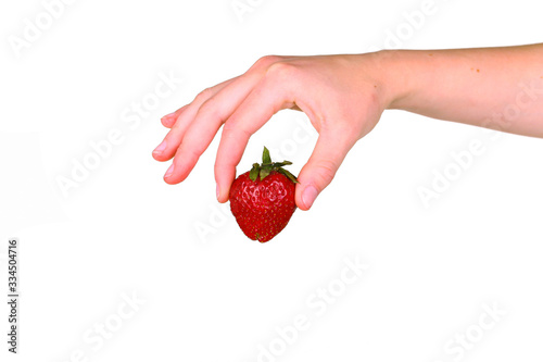 Female hand holding a fresh sweet strawberry isolated on white background.
