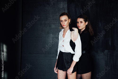 portrait of two beautiful fashionable women next to a friend
