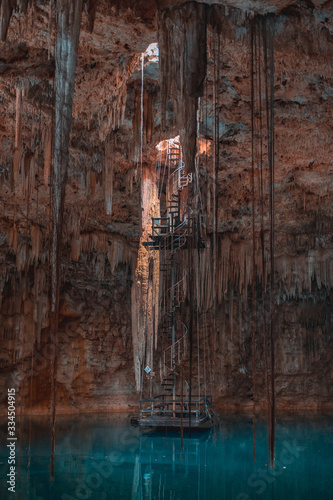 Girl in a cave with a blue cenote lake on the Yucatan