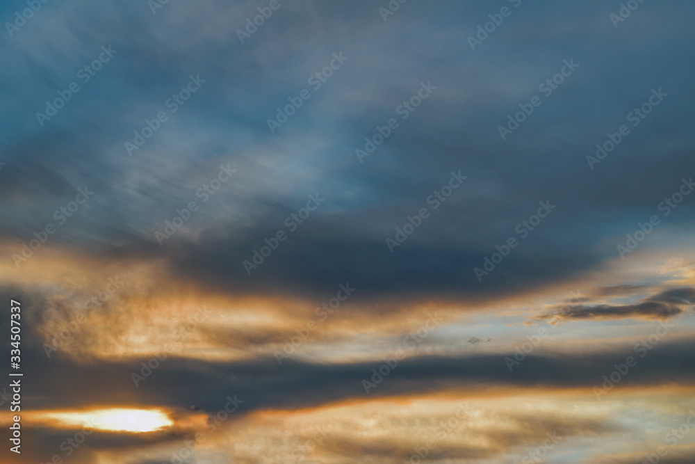 The sky at sunset. Cumulus clouds lit by the rays of the setting sun.