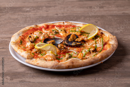 close up of sea food pizza on wooden background
