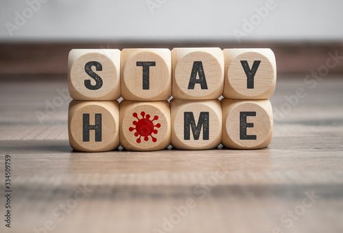 Cubes and dice with Stay Home and corona virus on wooden background