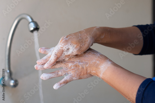 Muslim women wash hand with soap alcohol gel for sanitizer in kitchen sink concept for prevent Hygiene health care. Quarantine Islam people spread of germs and microbe bacteria outbreak coronavirus 19