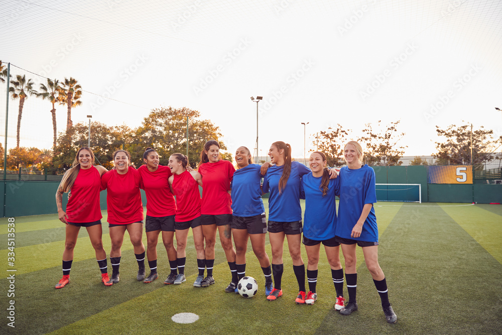 Womens Football Team Hugging After Training For Soccer Match On Outdoor Astro Turf Pitch