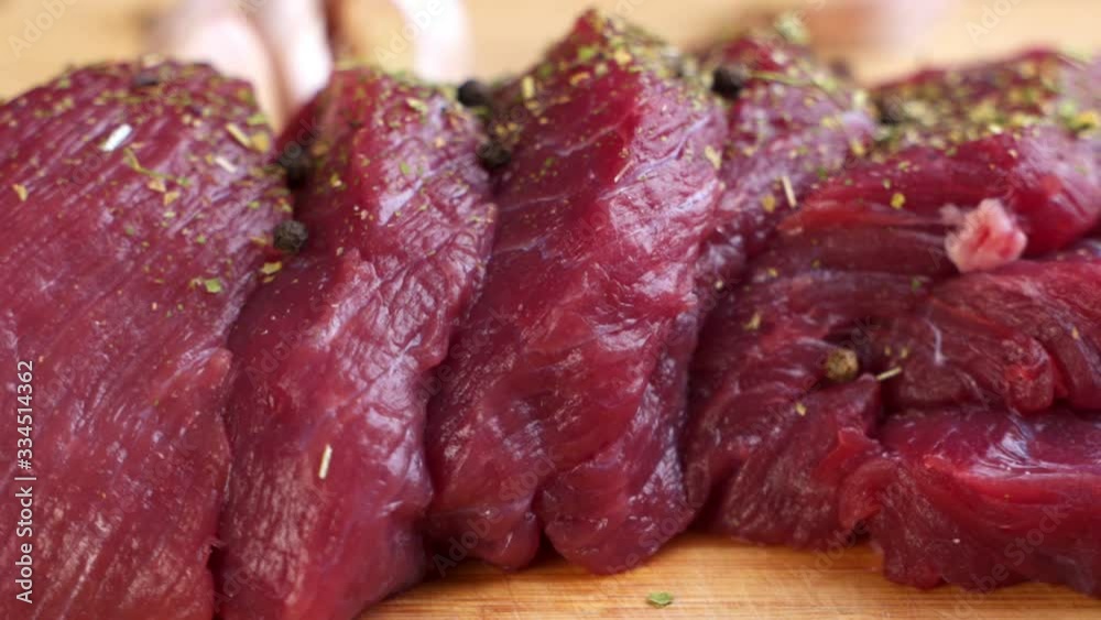 Fresh raw beef meat with peppercorns ready to grill, rotating Fresh raw beef meat with peppercorns ready to grill, rotating