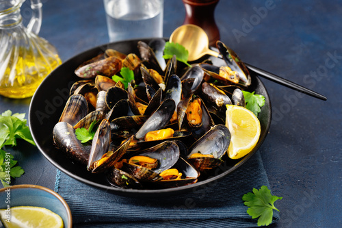 Close up of a plate with freshly coocked mussels on dining table photo