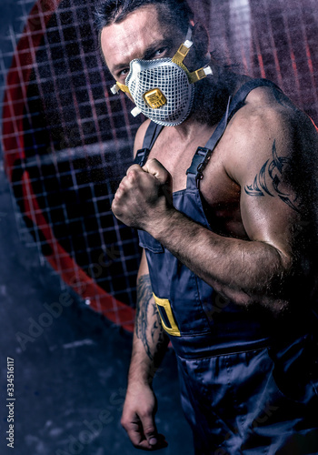 Man wearing respirator ffp3 typy. Worker in th the dust. Dirty mine. Miner on the background of ventilation photo