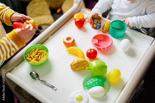 Two children entertain themselves with food toys. Playing at home during confinement