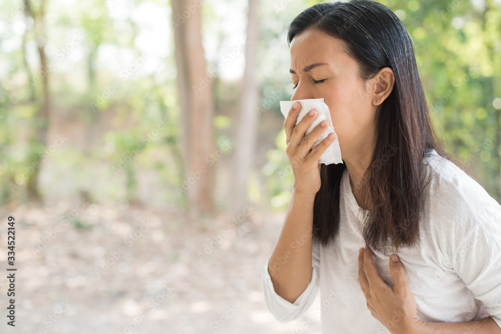 middle-aged women with cold blowing her runny nose with tissue. portrait asian middle-aged women get sick sneezing from flu, allergy symptoms coughing holding napkin. healthcare and medical concept. middle-aged women with cold blowing her runny nose with tissue. portrait asian middle-aged women get sick sneezing from flu, allergy symptoms coughing holding napkin. healthcare and medical concept.