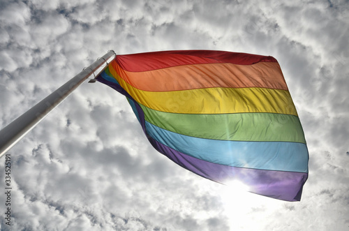 LGBTQI flag on blue sky during pride parade