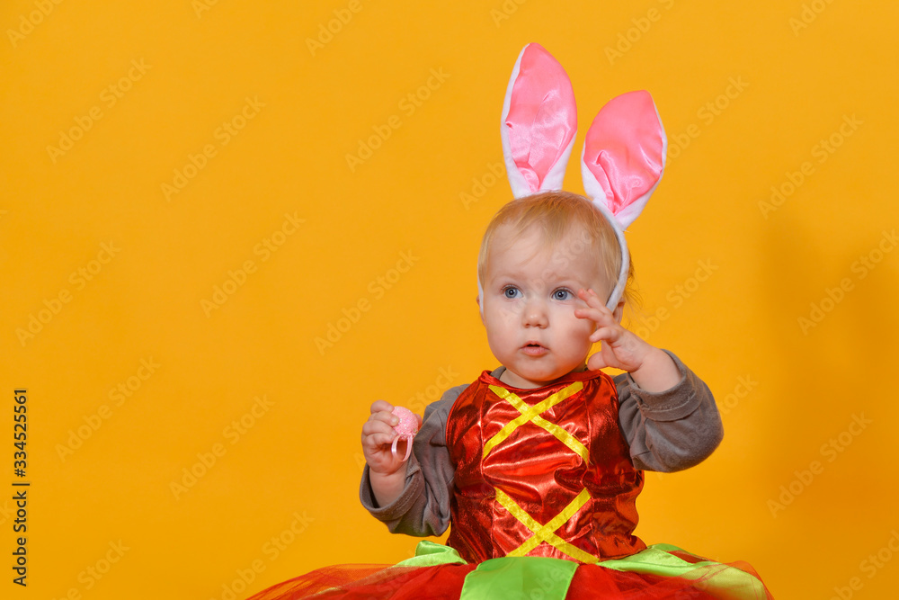 A small child, a girl clown with rabbit ears holds Easter eggs in her hands. A small child, a girl clown with rabbit ears holds Easter eggs in her hands.