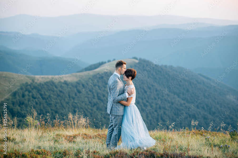 Wedding couple kissing in mountains at sunset Wedding couple kissing in mountains at sunset