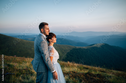 Bride and groom embracing in mountains. Outdoor wedding.