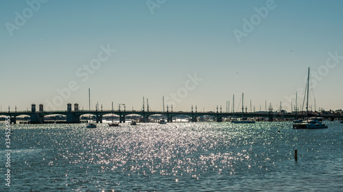 Draw Bridge and Sailboats Lying at Anchor Across Sparkling Water