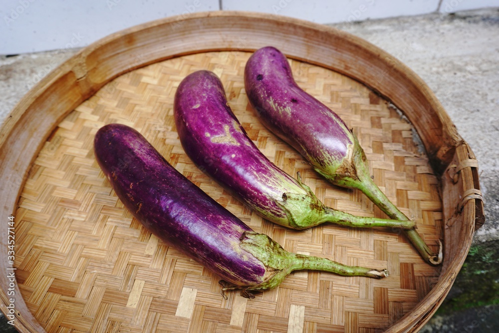 purple eggplants in a bamboo woven container purple eggplants in a bamboo woven container