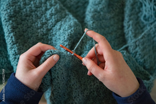 Woman's hands crochet background.  Looking down on Woman's hands  Crocheting blue yarn
