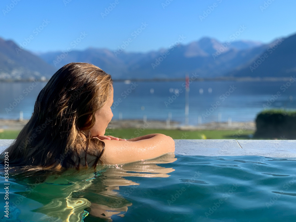 Junge Frau entspannt beim Wellness in den Bergen in einem schönen Pool Junge Frau entspannt beim Wellness in den Bergen in einem schönen Pool