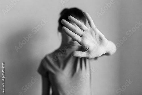 Stop domestic violence. The girl covers her face with her hand and asks for help. Domestic violence against women. photo