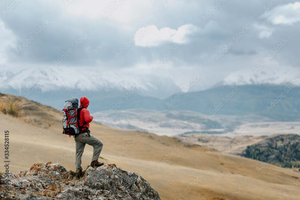 Man Traveler with Backpack hiking in the Mountains. Vacation concept