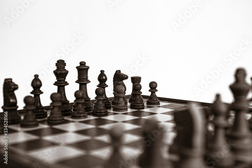 Chess pieces lined up on the chessboard. Concept picture concerning decision making and strategy. Black and white.