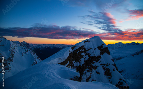 Colorful winter sunset on the top of Mons Avium Peak in Switzerland.