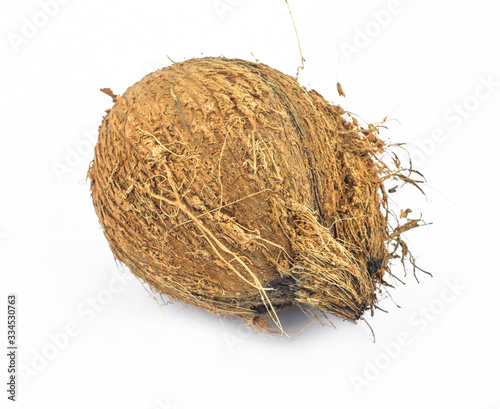 Angle view of a rustic coconut in the middle of an isolated white background