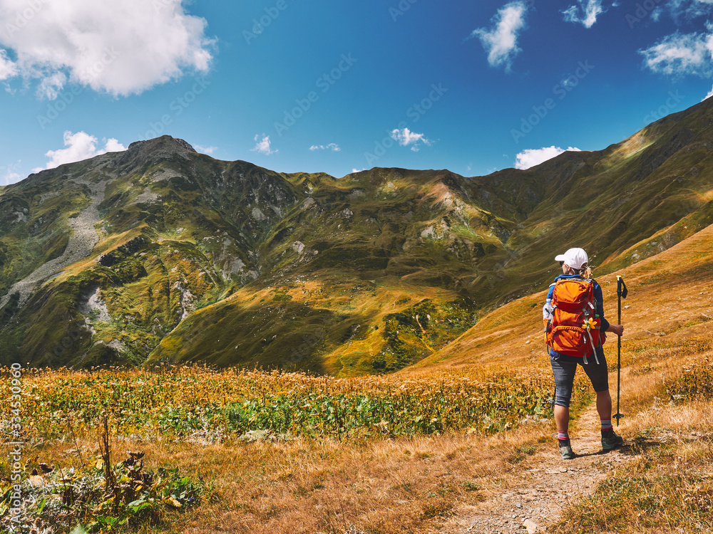 Young tourist backpacker girl enjoying a spectacular view of Caucasus mountains near Guli Pass