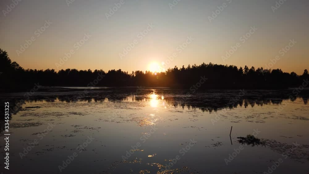 Sunset over still lake by forest in northern Sweden Sunset over still lake by forest in northern Sweden