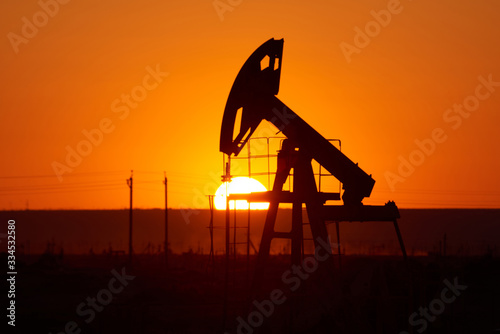 Oil pump on a sunset background. World Oil Industry.