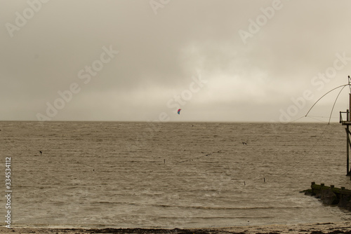 Les Moustiers en Retz en Loire atlantique kitesurf par tous les temps et pêche au carrelet au bout d'un ponton sur la côte et le rivage