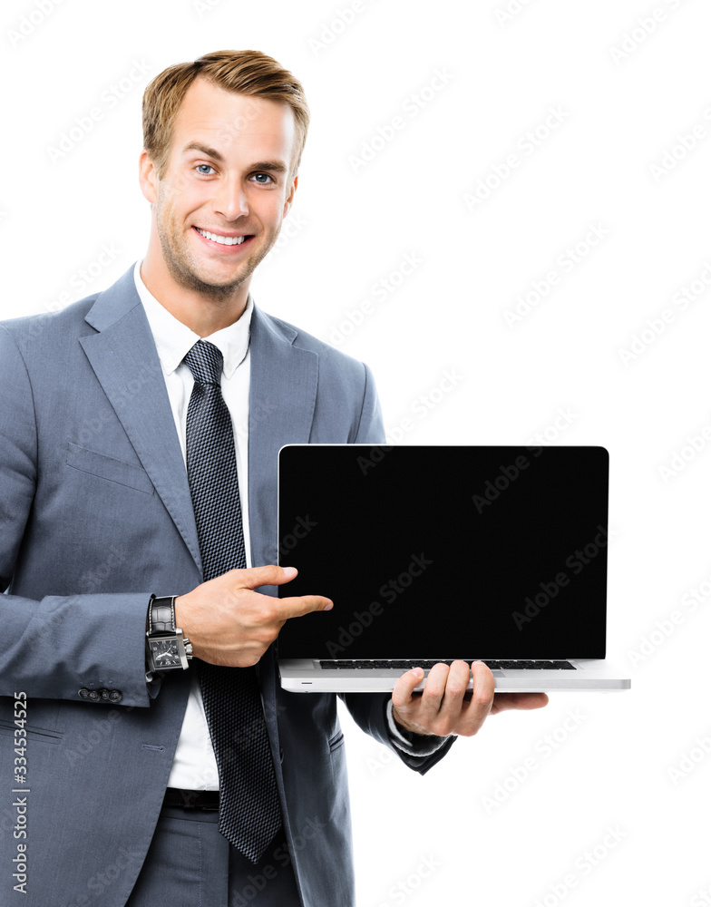 Smiling attractive businessman in grey confident suit, showing blank laptop monitor, isolated against white background, with copy space area for some slogan, imaginary, ad or text. Smiling attractive businessman in grey confident suit, showing blank laptop monitor, isolated against white background, with copy space area for some slogan, imaginary, ad or text.