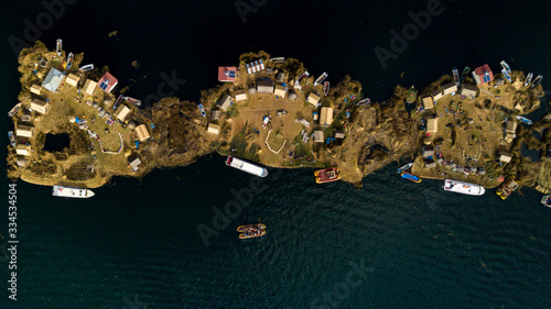 Aerial top view photo of floating islands on Lake Titicaca in Peru - a habitant of indigenous community Uros who are living on floating self-made islands made of totora plant 