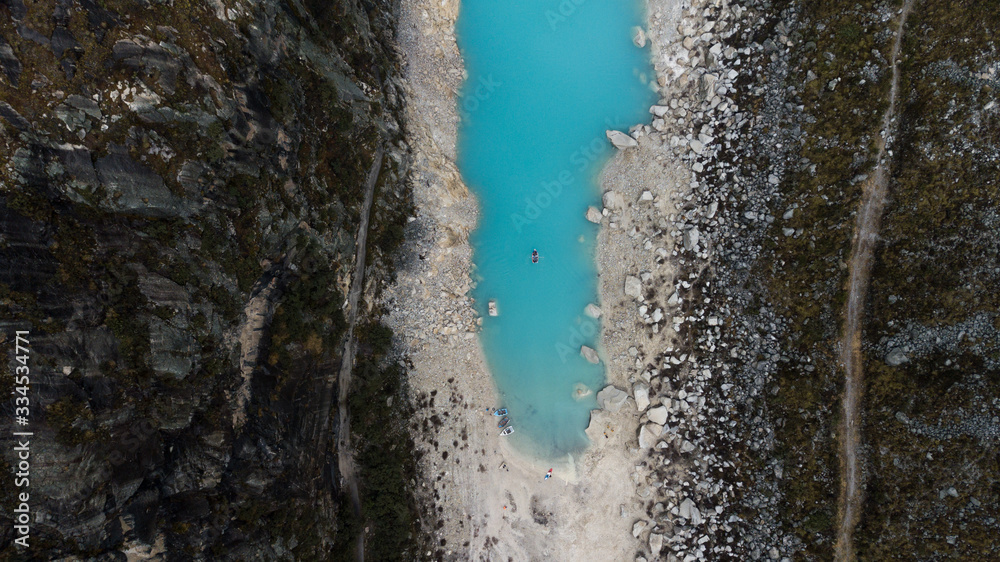 Aerial top view on turquoise water lake surrounded by rocks and sand in Huaraz, National Park, Peru - highest mountainous range in South America. Aerial top view on turquoise water lake surrounded by rocks and sand in Huaraz, National Park, Peru - highest mountainous range in South America.