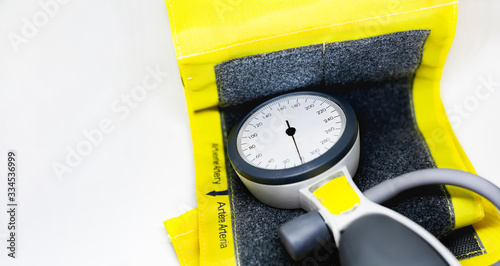 Foto a portable sphygmomanometer resting on a yellow cuff for adults with a velcro closure