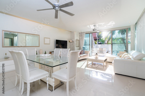 White furniture with sofa, dining table and ceiling fan in living room of villa, house, home, condo and apartment