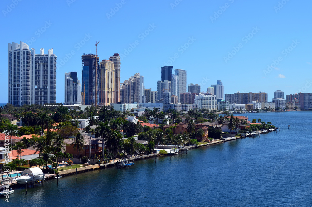 Luxury condo skyline and a gated island community of the sores of the Florida Intra-Coastal Waterway.