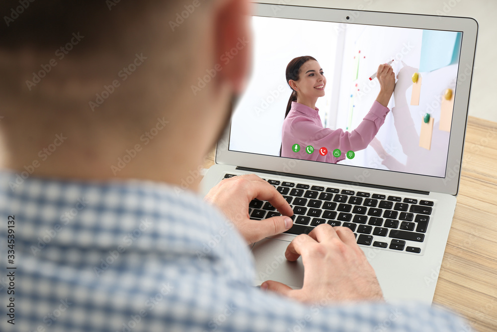 Young man watching video at desk, closeup. Online learning - obrazy, fototapety, plakaty 