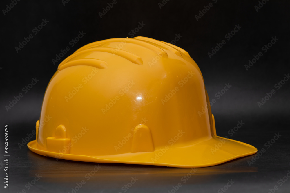 Fototapeta premium Yellow hard hat on dark background