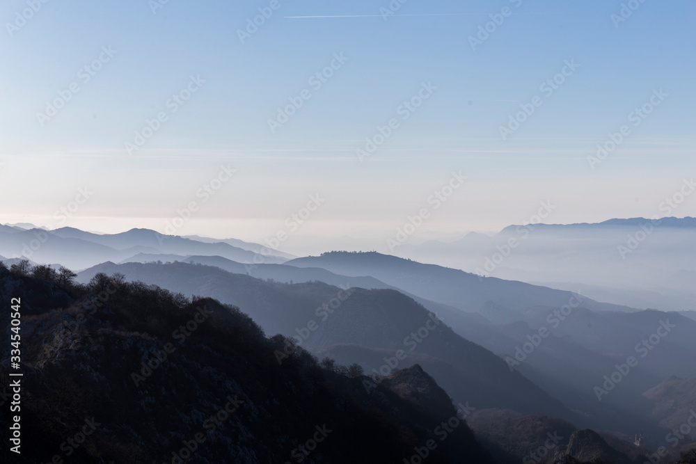 mountain landscape, on the horizon you can see the silhouettes of the mountains with different shades of blue