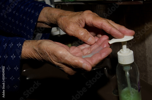 Older woman washing her hands to prevent coronavirus